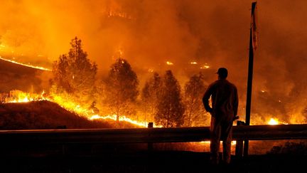 Un pompier contemple les flammes qui s'approche de la Highway 20 pr&egrave;s du lac Clear, en Californie, dimanche 2 ao&ucirc;t 2015. Le feu a d&eacute;j&agrave; ravag&eacute; plus de 10 000 hectares, et les soldats du feu ont contenu &agrave; peine 5% de l'incendie. (JOSH EDELSON / AFP)