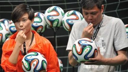 Le chanteur Li Yuchun et l'ex-footballeur Fan Zhiyi à Pékin, en Chine, le 12 juin 2014. (AFP/Cao Ji)