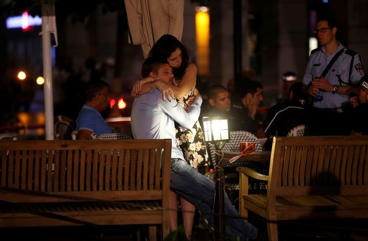 Des clients se serrent dans les bras, après l'attaque de terrasses à Tel-Aviv (Israël) mercredi 8 juin. (BAZ RATNER / REUTERS)