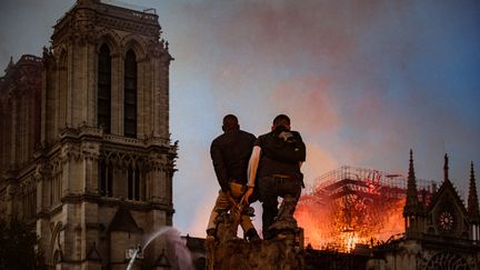 Le feu ne s'arrête pas et continue de détruire la cathédrale emblématique de la ville de Paris. Au Square René Viviani, juste en face de l'édifice construit il y a&nbsp;850 ans, des spectateurs effarés se hissent pour ne rien manquer de la scène.&nbsp; (SIMON GUILLEMIN / HANS LUCAS)