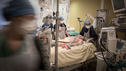 Des soignants s'occupent d'un patient atteint par le coronavirus dans l'unité de soins intensifs de l'Hôpital de Lariboisière à Paris le 27 avril 2020.&nbsp; (JOEL SAGET / AFP)