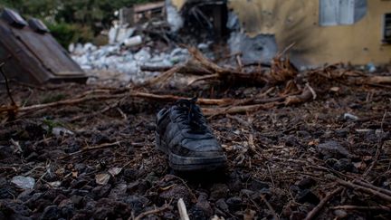 Une botte devant une maison du kibboutz de Be'eri, en Israël, le 11 octobre 2023. (MARTIN DIVISEK / MAXPPP)