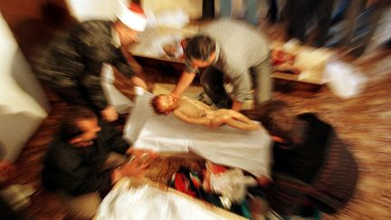 Un homme place un enfant albanais, tué par des soldats yougoslaves alors qu'il traversait la frontière entre l'Albanie et le Kosovo avec sa famille, dans un cercueil, le 23 octobre 1998 à Gercina (Yougoslavie). (YANNIS BEHRAKIS / REUTERS)