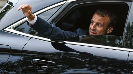 Le président Emmanuel Macron salue la foule à travers la vitre de son véhicule, à son arrivée en vacances au fort de Brégançon (Var), le 3 août 2018. (BORIS HORVAT / AFP)