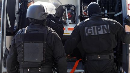 Des policiers du Groupe d'intervention de la police nationale apr&egrave;s une perquisition dans un immeuble de Cannes (Alpes-Maritimes), le 6 octobre 2012. (JEAN-CHRISTOPHE MAGNENET / AFP)