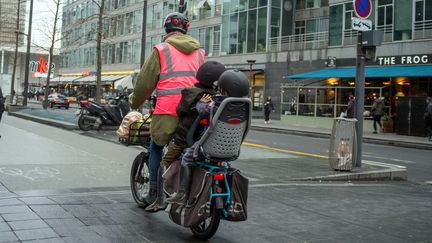 Une femme transporte des enfants à vélo à Paris, le 8 janvier 2020.&nbsp; (BRUNO LEVESQUE / MAXPPP)