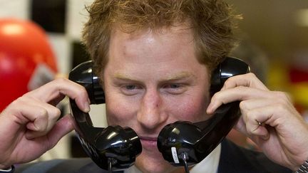 Le prince Harry plaisante au t&eacute;l&eacute;phone lors du traditionnel&nbsp;Charity Day de l&rsquo;op&eacute;rateur de march&eacute;s financiers ICAP &agrave; LOndres (Royaume-Uni), le 3 d&eacute;cembre 2014. (HEATHCLIFF O'MALLEY / AFP)