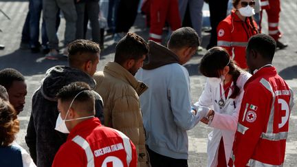 Une équipe de la Croix-Rouge vérifie la santé des migrants arrivés dans le port de Catane (Sicile), le 6 mai 2017. (DARRIN ZAMMIT LUPI / REUTERS)