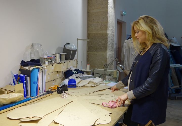 La créatrice Laura Foulquier (société Lorafolk) devant des patrons de vêtements dans son atelier-boutique parisien.
 (Corinne Jeammet)