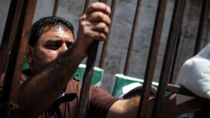 A Gaza, le 10 mai 2014, un Palestinien se met en scène dans une cage avec une pancarte en arabe: «Je suis en grève de la faim pour les prisonniers.» (Photo par Momen Faiz / NurPhoto)