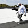 Un peintre de l'entreprise Cool Roof repeint en blanc le toit du laboratoire MGD-Nature, à Brandérion (Morbihan), le 25 mai 2021. (PHOTOPQR/LE TELEGRAMME/MAXPPP)