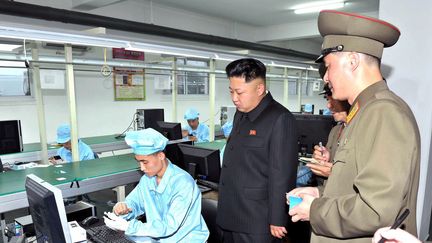 Le leader nord-cor&eacute;en Kim Kong-Un inspecte le processus de production d'un t&eacute;l&eacute;phone mobile, dans une usine du pays. Le clich&eacute;, non dat&eacute;, a &eacute;t&eacute; diffus&eacute; le 11 ao&ucirc;t 2013 par l'agence d'information officielle KCNA. (KCNA / AFP)