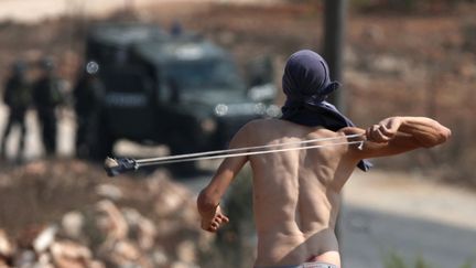 Un Palestinien utilise un lance-pierres contre des policiers isra&eacute;liens &agrave; Nabi Saleh (Cisjordanie), le 28 septembre 2012. (ABBAS MOMANI / AFP)