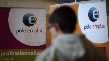 Un homme passe devant une affiche Pôle emploi, le 8 mars 2017 à Dunkerque (Nord). (PHILIPPE HUGUEN / AFP)