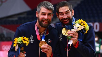 Les handballeurs Luka et Nikola Karabatic (de g.à dr.) brandissent leur médaille olympique, le 7 août 2021, à Tokyo. (FRANCK FIFE / AFP)