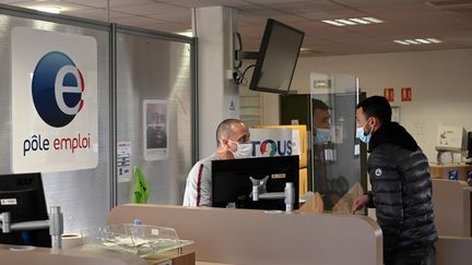 Un conseiller Pôle Emploi renseigne une personne à l'agence de Chateau-Gombert à Marseille, le 14 décembre 2020. (NICOLAS TUCAT / AFP)