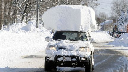 Une voiture croule sous la neige apr&egrave;s qu'une temp&ecirc;te historique a enseveli l'&eacute;tat de New York (Etats-Unis), le 19 novembre 2014. (GARY WIEPERT / AP / SIPA)