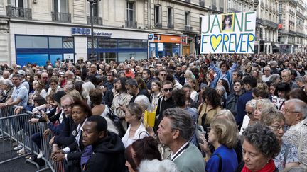 Les fans de Jane Birkin devant le grand écran diffusant la cérémonie de funérailles de la chanteuse, le 24 juillet 2023, à Paris. (GEOFFROY VAN DER HASSELT / AFP)