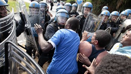 Des policiers italiens dispersent environ 200 migrants rassembl&eacute;s pr&egrave;s de la fronti&egrave;re avec la France, &agrave; Vintimille (Italie), le 13 juin 2015. (JEAN-CHRISTOPHE MAGNENET / AFP)