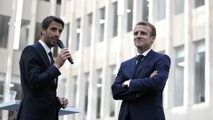 Le patron de Paris 2024 Tony Estanguet (à gauche) et le président Emmanuel Macron échangent avec des membres du Comité d'organisation des Jeux olympiques et paralympiques de Paris 2024, à Saint-Denis, le 14 octobre 2021.&nbsp;
 (FRANCOIS MORI / AFP)