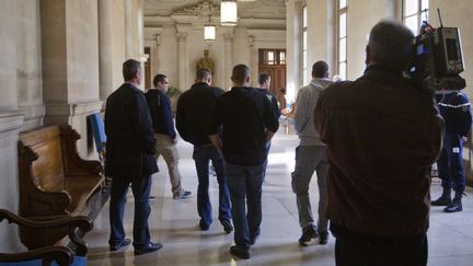 Un cameraman filme de dos, le 2 novembre 2011 au palais de justice de Paris, des policiers d'Aulnay-sous-Bois (Seine-Saint-Denis), venus soutenir leurs coll&egrave;gues lors de leur proc&egrave;s en appel. (JOEL SAGET / AFP)