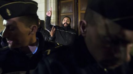 L'humoriste Dieudonn&eacute; M'Bala M'Bala mime un "soleil", un geste de ralliement de ses sympathisants, le 4 f&eacute;vrier 2015, au palais de justice de Paris. (MAXPPP)