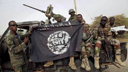 Des militaires nigérians brandissent, le 23 août 2016, un drapeau de Boko Haram saisi dans la ville de Damasak (à la frontière avec le Niger), reprise en 2015 au groupe djihadiste. (REUTERS/Emmanuel Braun/File Photo)