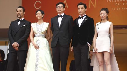 Les acteurs (en partant de la gauche) Liao Fan, Kwai Lun-Mei, le réalisateur chinois Diao Yinan, et les acteurs Hu Ge et Wan Qian posent derrière le palais des Festival pour la présentation du Lac des oies sauvages. Le film est en compétition pour la Palme d'or. (ARTHUR MOLA/AP/SIPA / AP)