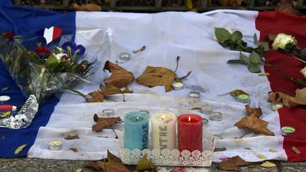 Des bougies, des fleurs et le drapeau français, déposés près du Bataclan, à Paris, le 18 novembre 2015.&nbsp; (DOMINIQUE FAGET / AFP)