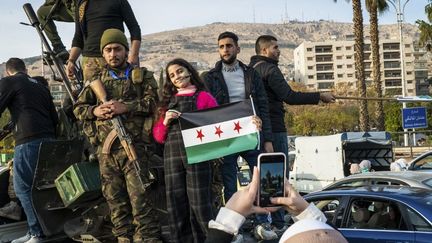 Des habitants de Damas (Syrie) posent avec des rebelles, le 11 décembre 2024. (NAEL CHAHINE / MIDDLE EAST IMAGES / AFP)