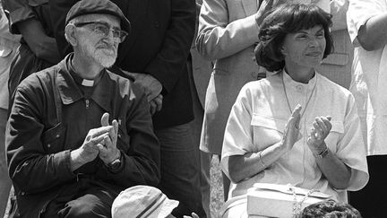 Danielle Mitterrand, l'&eacute;pouse du pr&eacute;sident Fran&ccedil;ois Mitterrand est au c&ocirc;t&eacute; de l'abb&eacute; Pierre, fondateur de l'association caritative "Les Compagnons d'Emma&uuml;s &agrave; Amilly (Loiret), le 06 juillet 1985. (AFP)