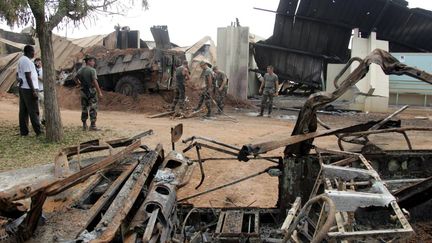 Des soldats français dégagent les débris de l'épave d'un véhicule blindé au lycée Descartes de Bouaké, qui servait de base aux soldats français, le&nbsp;10 novembre 2004. (PHILIPPE DESMAZES / AFP)