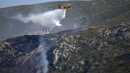 Un canadaire largue de l'eau pour éteindre un feu de forêt dans le vallon de Saint-Cyr à Marseille, le 16 août 2021. Photo d'illustration. (PENNANT FRANCK / MAXPPP)