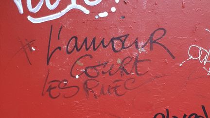 Le tag "l'amour court les rues", dans le 18e arrondissement de Paris, de Wilfrid A, accusé de viols et agressions sexuelles par 25 femmes.&nbsp; (STÉPHANIE BERLU / FRANCE-INFO)