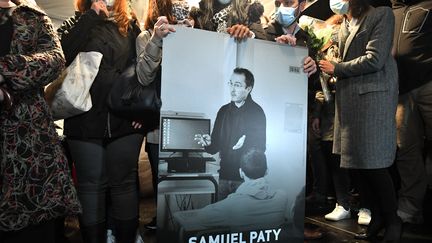 Des collègues et des proches de Samuel Paty tiennent un portrait du professeur, le 20 octobre 2020. (BERTRAND GUAY / AFP)