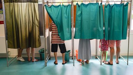 Des électeurs dans l'isoloir à Saumur (Maine-et-Loire), lors du premier tour des élections législatives du 12 juin 2022. (FREDERIC PETRY / HANS LUCAS / AFP)