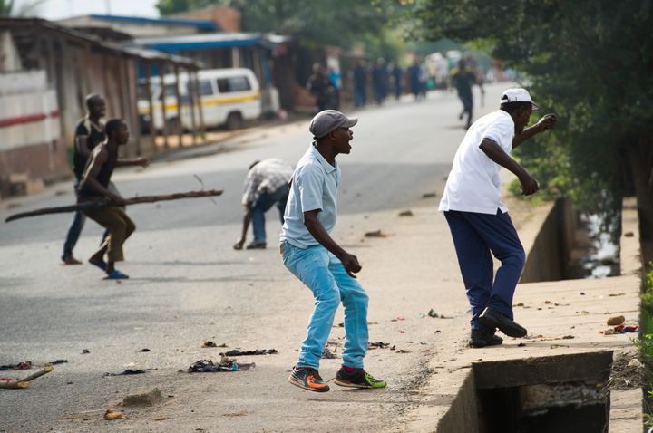 Des&nbsp;Imbonerakure, la jeunesse du parti pr&eacute;sidentiel burundais, jettent des pierres sur des manifestants &agrave; Bujumbura, le 7 mai 2015. (PHIL MOORE / AFP)