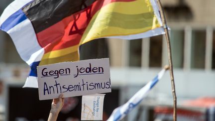 Une personne manifeste à Bonn (Allemagne) en brandissant une pancarte où l'on peut lire "contre tous les antisémitismes", le 19 juillet 2019. (MAXPPP)