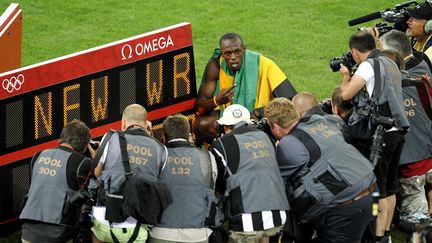 Le coureur jama&iuml;cain Usain Bolt devant le panneau indiquant son record du monde du 200 m aux JO de P&eacute;kin (Chine), le 20 ao&ucirc;t 2008. (FAUGERE / DPPI / SIPA)