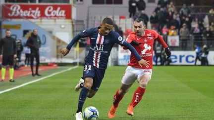 Le joueur du PSG Colin Dagba au duel avec Yohan Court; le joueur du Stade Brestois (DAMIEN MEYER / AFP)