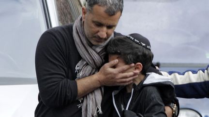 Un &eacute;colier est escort&eacute; &agrave; sa sortie de l'&eacute;cole juive Ozar Hatorah apr&egrave;s la fusillade, Touliuse (Haute-Garonne), le 19 mars 2012. (JEAN-PHILIPPE ARLES / REUTERS)