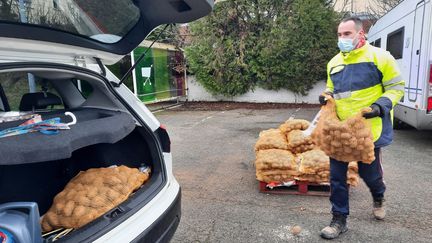 Un des ouvriers agricoles de Virginie aide les clients à charger les pommes de terre dans leur voiture (FARIDA NOUAR / FRANCEINFO / RADIO FRANCE)