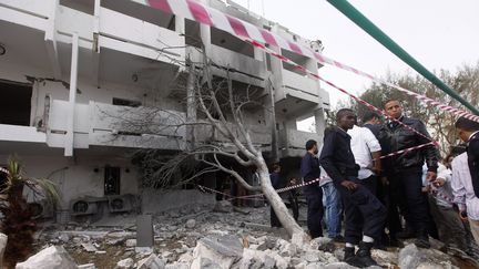 Des habitants de Tripoli (Libye) inspectent l'ambassade de France, attaqu&eacute;e par une voiture pi&eacute;g&eacute;e le 23 avril 2013 au matin. (ISMAIL ZETOUNI / REUTERS)