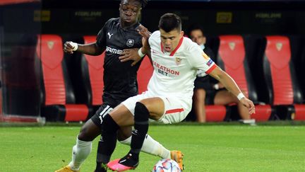 Jeremy  Doku (Rennes, à gauche) à la lutte avec Marcos Acuna (FC Séville). (CRISTINA QUICLER / AFP)