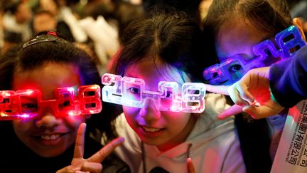 Des enfants portent des lunettes "2018" à Hong Kong (Chine). (TYRONE SIU / REUTERS)