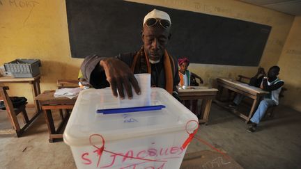 Un Ivoirien glisse son bulletin dans l'urne pour les &eacute;lections l&eacute;gislatives le 11 d&eacute;cembre &agrave; Bouake (C&ocirc;te d'Ivoire). (ISSOUF SANOGO / AFP)