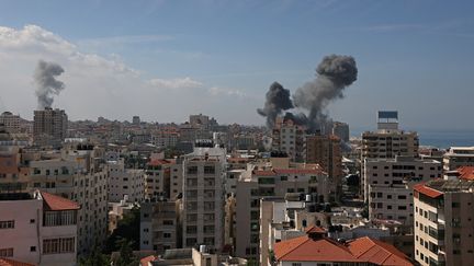 De la fumée s'échappe d'immeubles résidentiels après des frappes aériennes israéliennes dans la ville de Gaza, le 7 octobre 2023. (MOHAMMED ABED / AFP)