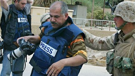 sont contrôlés par les marines près de l’hôtel Palestine à Bagdad, 10-4-2003.

48 h plus tôt, des tirs américains contre l’hôtel avaient tué les cameramen Taras Protsyuk et José Couso (télé espagnole).

En 2008, un ancien sergent, du renseignement américain, révèle que son gouvernement avaient classé l’hôtel commecible militaire.

En 2011, Wikileaks dévoile que les USA ont fait pression sur l’Espagne pour classer l'enquête. (AFP PHOTO / PATRICK BAZ)