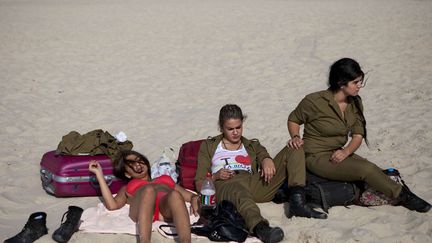 Bain de soleil pour trois soldates isra&eacute;liennes sur une plage de Tel Aviv (Isra&euml;l), le 24 juin 2012. (ODED BALILTY / AP / SIPA)