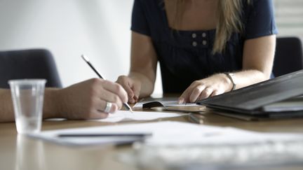 Une femme dans une réunion de travail. Image d'illustration. (MICHAEL BLANN / PHOTODISC)